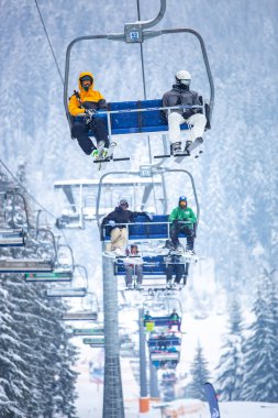 Bukovel, Ukrayna - 19 Mart, 2018: sandalye Asansör kayakçı ve Snowboard düşkünleri kış tatil için. Etkin turistler üzerinde snowboard binmek için Asansör ve kayaklar Bukovel Winter Park Karpat Dağları