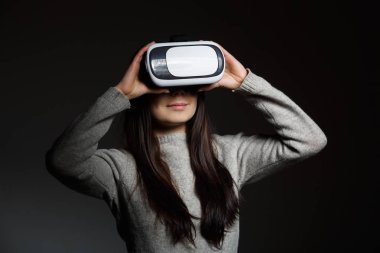 Sanal gerçeklik ile oynayan genç esmer kız portresi stüdyo mobil oyun uygulama için koruyucu gözlük. Kız mobil oyunlar apps ile yenilikçi 3d vr kulaklık kullanın. Trendy artar gerçeklik aygıtı kullanımda