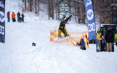 Bukovel, Ukrayna-19 Mart, 2018: Genç snowboard atlet rampa Kayak Park Bukovel kış kar tahtada yapmak hava hüner Park.Sportsman yarışmada doğa kış sporları sırasında atlar