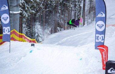 Bukovel, Ukrayna-19 Mart, 2018: Genç snowboard atlet rampa Kayak Park Bukovel kış kar tahtada yapmak hava hüner Park.Sportsman yarışmada doğa kış sporları sırasında atlar