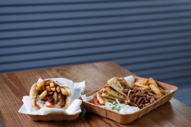 Geleneksel Yunan fast food restoran menü. Yunanistan Souvlaki ve döner et sandviç yemek kağıt tabak içinde servis. Kavrulmuş lezzetli fastfood Cafe tablo. Yemeğin keyfini çıkarın