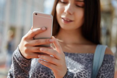 Modern smartphone kullanan beyaz esmer kız. Elleri büyük gümüş telefon modeli