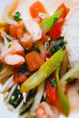 Çin salatası malzemelerin üzerine kapatın. Karides, domates ve baharat haşlanmış kereviz, beyaz plaka üzerinde beyaz Asya pirinç ile devam eder. Gıda makro çekim.