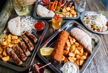 Fast food restoran menüde lezzetli geleneksel Sırp yemek keyfini çıkarın. Egzotik menü öğle yemeği için. Izgara Dana eti, kızarmış peynir ve kızarmış patates kafede görev yaptı. Gıda kompozisyon arka plan