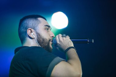 Moskova - 30 Kasım, 2016: popüler rap şarkıcısı şarkı gece kulübünde sahnede. Büyük müzik kulübünde konser göster. Parlak sahne aydınlatma, kalabalık dans pistine. Rapçi şarkı canlı. Eğlence olay