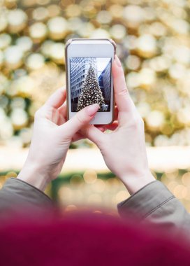 Noel ağacı açık havada genç esmer kız poz, açık renklerle dekore edilmiş