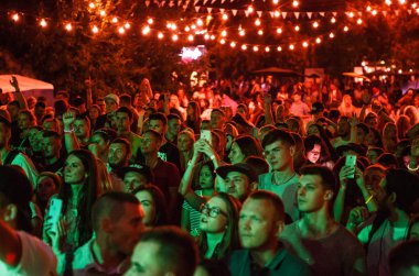 Kiev-11 Temmuz, 2018: Grup konserde parlak kırmızı ve yeşil sahne ışıkları üzerinde parti genç insan. Konser kalabalık parti Bazar Festivali olay açık