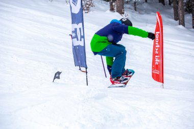 Bukovel, Ukrayna-19 Mart, 2018: Genç snowboard atlet rampa Kayak Park Bukovel kış kar tahtada yapmak hava hüner Park.Sportsman yarışmada doğa kış sporları sırasında atlar