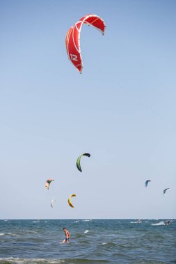Odessa-25 Ağustos, 2017: Kitesurfing Karadeniz üzerinde. Genç ve aktif sporcular için eğlenceli su sporları. İnsanlar iyi yaz günde uçurtma sörf tahtası üzerinde dalgalar binmek