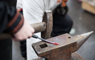 Demirci örs bulanık çekimde tekme. Shrovetide pagan Festivali kutlama. Rus Maslennica bahar tatil karnaval arka plan. Siyah smith kırmızı sıcak demir parçası üzerinde çekiç örs üzerinde çalışır