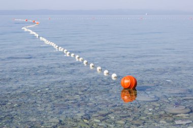 Emanet denizciler ve tehlikeli kayalar uzak yüzücüler suda tutmak için Adriyatik Denizi'nde sürüklenen şamandıralar. Turuncu şamandıra güneş altında açık denizde dalgalar üzerinde yüzen