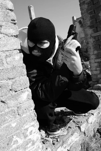 角を曲がったところで犠牲者を待っている黒いバラクラバマスクの犯罪者 — ストック写真
