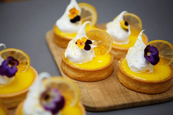 Eat delicious lemon tart cupcakes for coffee break in pastry cafe.Fresh bakery products with cream & lemon fruit slice.Biscuit base & creamy sweet topping.