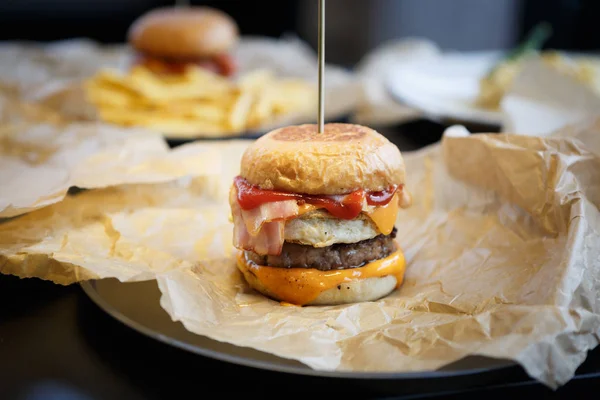 Huge fat burger in fast food restaurant menu.Delicious big tasty hamburger with beef meat cutlet, tomato ketchup sauce & burner cheese served on plate in fastfood cafe