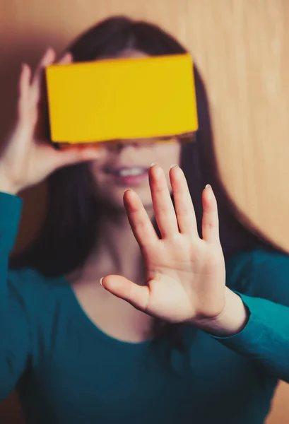 Cardboard gaming headset could be so much fun. This girl plays video game on her smart phone inside the box.