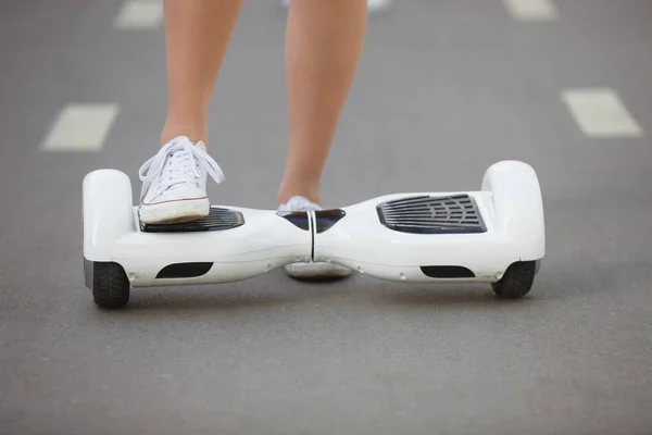公園で屋外電気ミニ ホバー ボード スクーターに乗って女の子の足 バッテリ電源で生態学的な都市交通大気汚染を生成しません — ストック写真