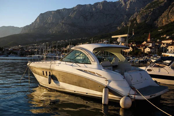 Comfortable white speed boat for rent.Rental yacht moored on pier in beautiful blue lagoon of Adriatic Sea in Croatia.luxury water craft for rent on summer vacation cruise.Travel destination for tourism