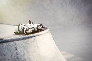 Agresif inline paten açık skate Park beton rampa üzerinde yalan. Paten hile ve biler, hiçbir modelleri için