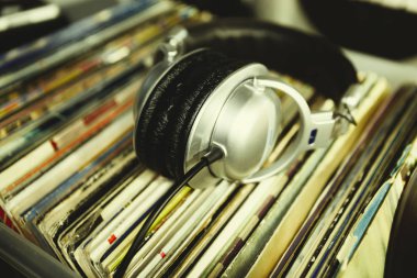 DJ kulaklık vinil kayıt üzerinde. DJ, ses meraklısı, müzik aşığı için analog kayıtlar ve koca kafa telefonlarının toplama.