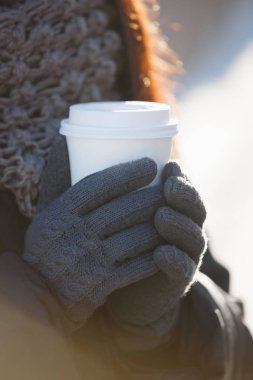 Kadın tutun temiz beyaz kağıt kahve kupa elinde. Açık kapuçino Kupası elinde tutan kız. Kafe, Restoran logo ve metin üzerinde dishware yerleştirin. Atış, dikey latte içmek odaklanmak