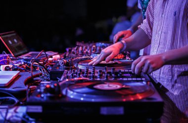 Kulüp partisi dj turntable ile müzik çalar. Gece kulübünde sahnede vinil kayıtlar çizilmeye hip-hop dj adam elinde. Sahnede profesyonel ses ekipmanları. Retro dönüş tablo oyuncu ve ses karıştırıcı