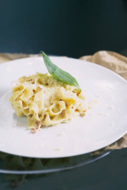 İtalyan makarna parmesan peyniri ile lezzetli taze pişmiş ve basel bırakır. Italy.Restaurant makarna yemek lezzetli mutfağı beyaz tabak içinde servis. Lezzetli yiyecekleri yakın, dikey atış