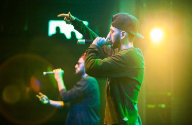 Moskova - 20 Ekim, 2016: Rap şarkıcı şarkı sahne gece kulübü. Hip hop müzik sanatçı şarkı mikrofon sahnede. Rapçi parlak konser aydınlatma.