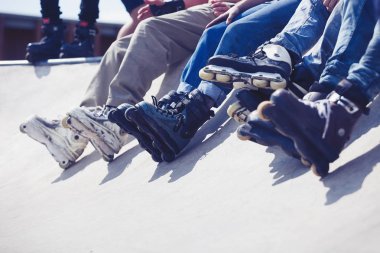 Açık skate Park beton rampa tepesinde duran agresif inline paten giymiş rollerbladers metrelik. Silindir bıçakları için hile ve biler giyen aşırı spor atlet