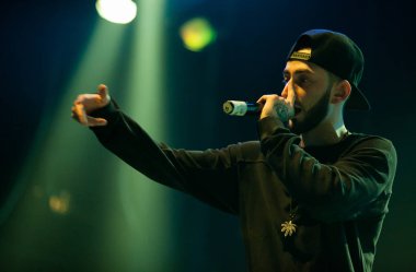 Moskova - 20 Ekim, 2016: Rap şarkıcı şarkı sahne gece kulübü. Hip hop müzik sanatçı şarkı mikrofon sahnede. Rapçi parlak konser aydınlatma.