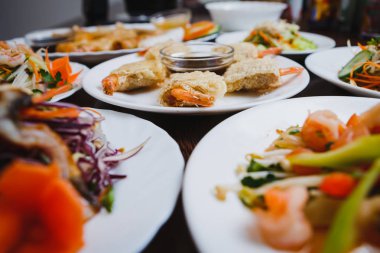 Egzotik yiyecek Restoran lezzetli Vietnam mutfağı menü. Kızarmış çıtır karidesli odaklanmak beyaz plaka üzerinde rulo. Taze renkli sebze salata ve deniz ürünleri Çin kafede. Asya gurme atıştırmalıklar