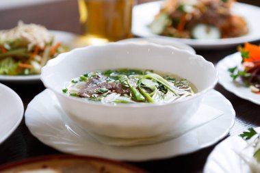 Popüler Vietnamca pho Bo şehriye çorbası ile haşlanmış Dana eti ve baharat beyaz kase hizmet. Kafede geleneksel Asya yemek menüsü. Restoran ve egzotik yemekler. İyi bir diyet için doğal maddeler