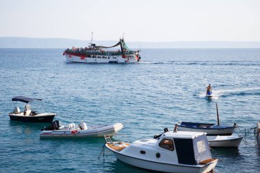 Makarska, Hırvatistan - 23 Haziran, 2017: turist yüzmek Adriyatik Sea.Beautiful beach Resort ile gemi. Yaz tatili için seyahat hedef