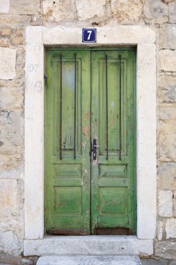 Makarska; Hırvatistan-29 Haziran; 2017: Eski mermer taş binada vintage yeşil ahşap kapılar. Eski Hırvat mimarisi arka plan. Pas ve çizikler ile Grungy kapı