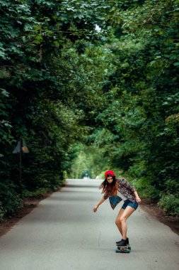 Parktaki kaykayda binmiş güzel bir kadın.
