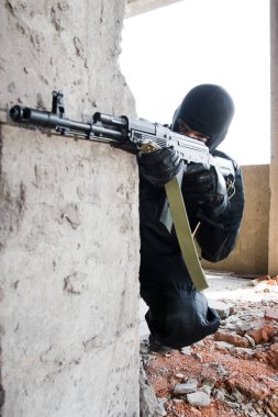 adam siyah kamuflaj bir ak-47 otomatik silah ile hedefleme 