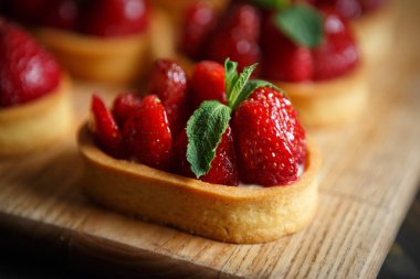 Nane yaprakları ve taze çilek ile deicious çilek cupcakes Tepesi üzerinde bisküvi tabanı üzerinde yemek. Cupcake Cafe tatlıya görüntüsünü kapatın. İtalyan tatlı gıda makro