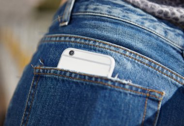 Kot pantolon cebinde büyük gümüş akıllı telefon. Kadar yakın, aracının kamera odak