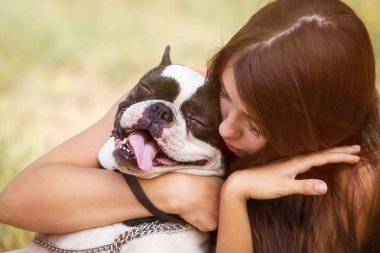 genç esmer kız parkta onun sağlıklı genç bulldog ile oynarken