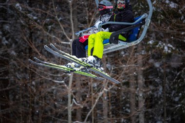 Bukovel, Ukrayna - 19 Mart, 2018: sandalye Asansör kayakçı ve Snowboard düşkünleri kış tatil için. Etkin turistler üzerinde snowboard binmek için Asansör ve kayaklar Bukovel Winter Park Karpat Dağları