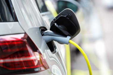 Yenilikçi hibrid elektrikli araba park yerinde şehrin sokak üzerinde güç kablosunu elektrik ile pilleri şarj. Temiz çevre araç ucuz elektrik motoru ile. Çevre hakkında bakım