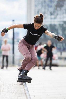 Kiev-24 Haziran, 2018: Demiryolu kutusu agresif inline paten üzerinde açık skatepark skate Yarışması ile genç beyaz kız biler. Doğa sporları arka plan. Serin gençlik yaşam tarzı. Kadın atlet bıçaklar rides