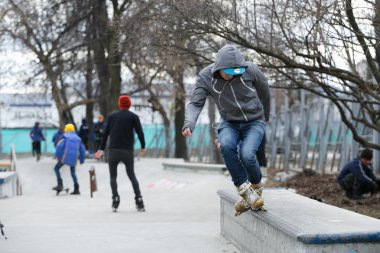 Moskova - 25 Mart, 2017: genç agresif Inline patenci adam eziyet çıkıntının üzerinde aşırı hatlı tekerlekli paten açık skate park sokak skate Yarışması sırasında demiryolu ile