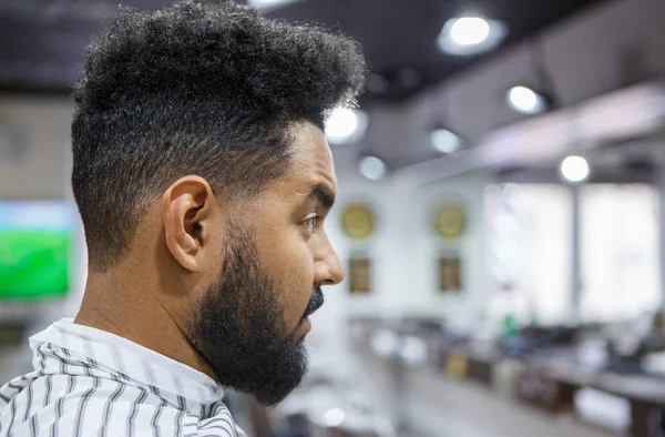 英俊的年轻黑色的肖像坐在理发店盖着毯子 等待理发师削减他的新发型和修剪 Mustach 男性美容治疗理念 — 图库照片