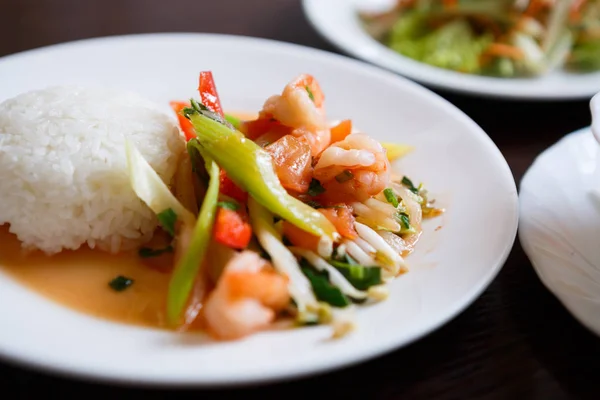 Exotic Vietnamese food restaurant menu close up.Traditional Asian dish served on white plate.Boiled fresh shrimps sea food,white Chinese rice,celery & vegetables