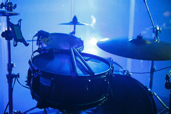 MOSCOW - 30 NOVEMBER, 2016 : Drummers drum set on scene in bright lights.Drums in focus. Professional concert audio drumming equipment. Musical instruments in blue light