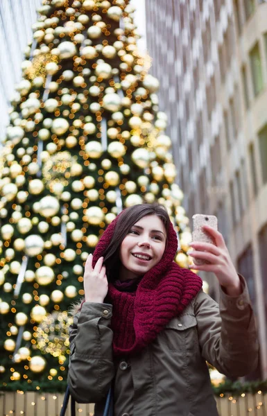 摆在明亮的年轻黑发女孩装饰圣诞树户外 — 图库照片