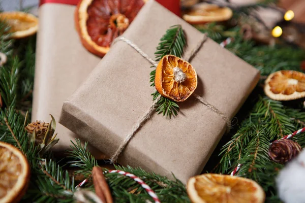 美丽的手工制作的圣诞礼品包装盒装饰棕色纸包装周围与天然冷杉树花圈 新年手工礼物和装饰细节近在咫尺 — 图库照片