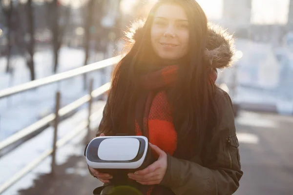Young woman walk outdoor with new virtual reality glasses for mobile gaming apps.Use mobile games applications on the go.Modern augmented reality gamer gadget.Pretty geek girl with innovative gadgets