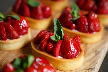 Nane yaprakları ve taze çilek ile deicious çilek cupcakes Tepesi üzerinde bisküvi tabanı üzerinde yemek. Cupcake Cafe tatlıya görüntüsünü kapatın. İtalyan tatlı gıda makro