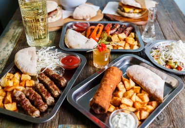 Fast food restoran menüde lezzetli geleneksel Sırp yemek keyfini çıkarın. Egzotik menü öğle yemeği için. Izgara Dana eti, kızarmış peynir ve kızarmış patates kafede görev yaptı. Gıda kompozisyon arka plan   